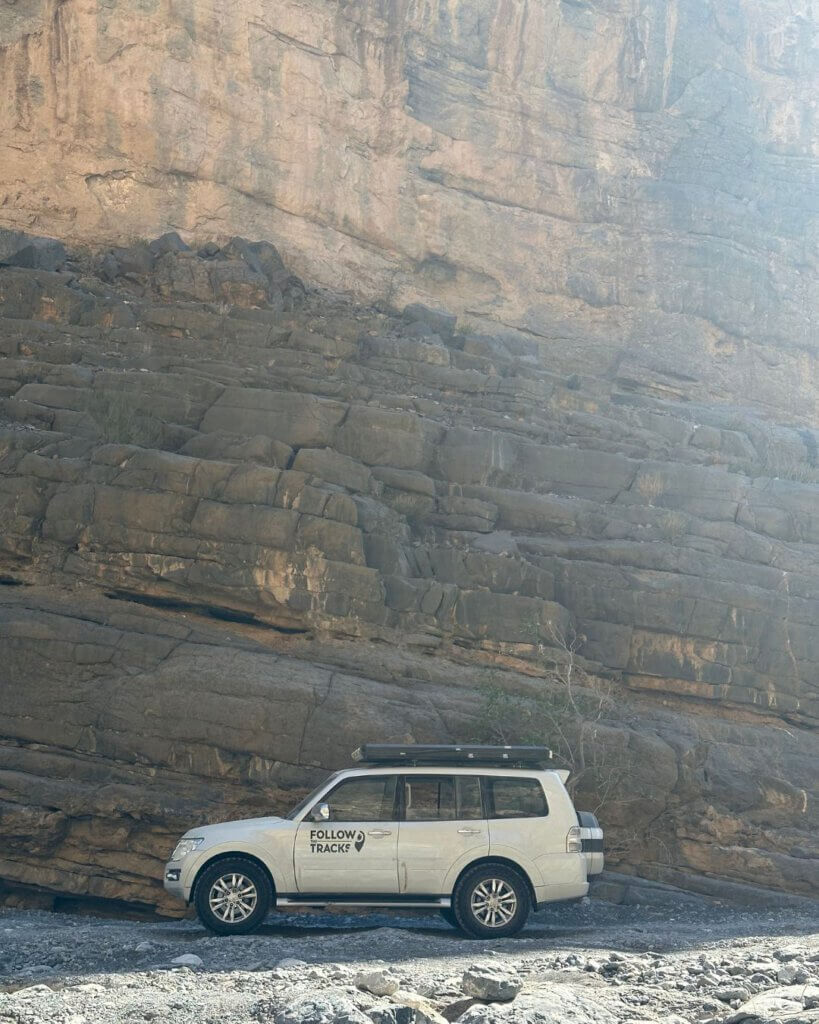 Off-road vehicle driving through Oman’s rugged desert tracks, ready for adventure.