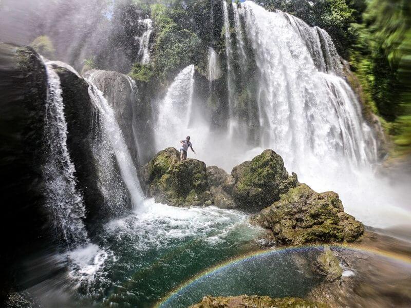 Jumping in the water at Standing below the Pulhapanzak Waterfalls