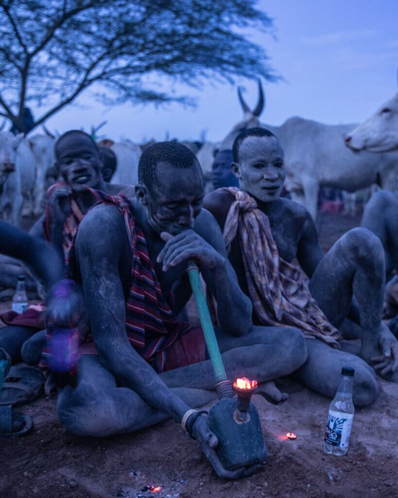 The local Mundari community smoking at twilight