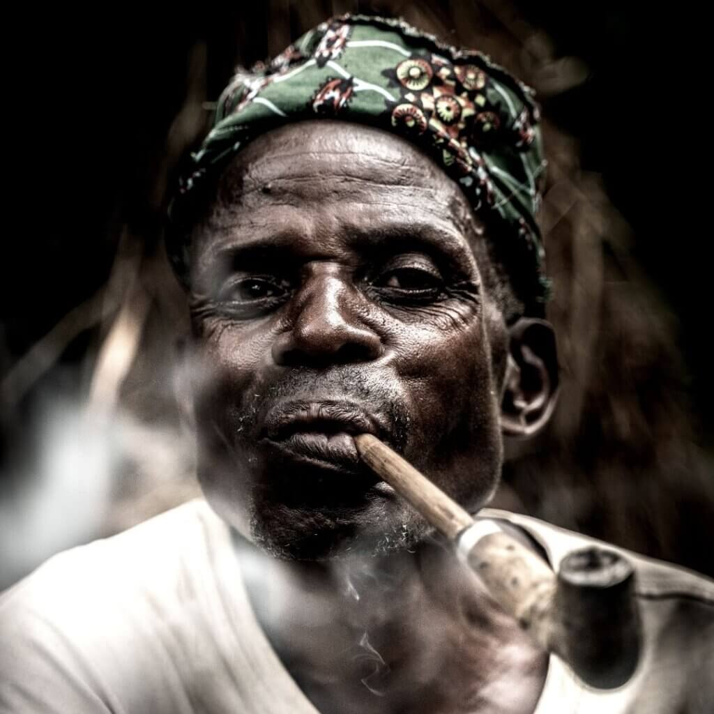 Batwa man smoking tobacco