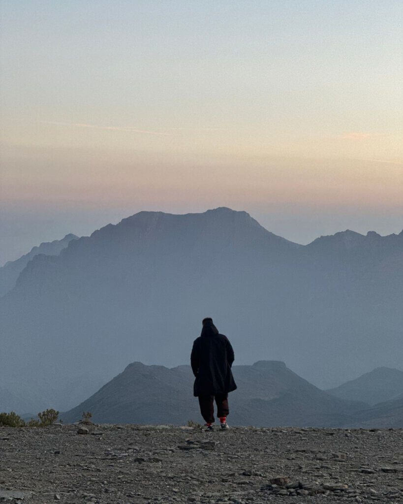 Traveler enjoying the breathtaking view from the top of Jebel Shams in Oman, known as the Grand Canyon of Arabia