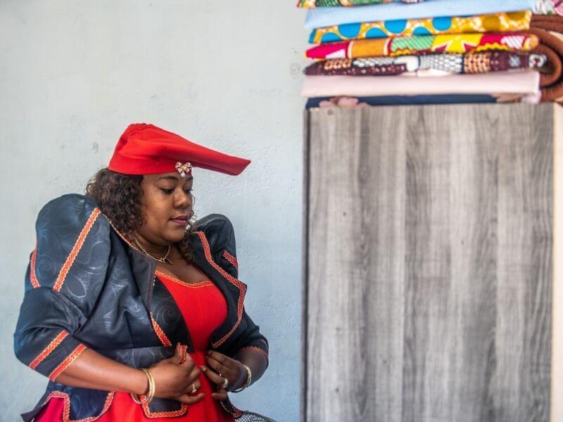 Herero woman dressing up her traditional attire