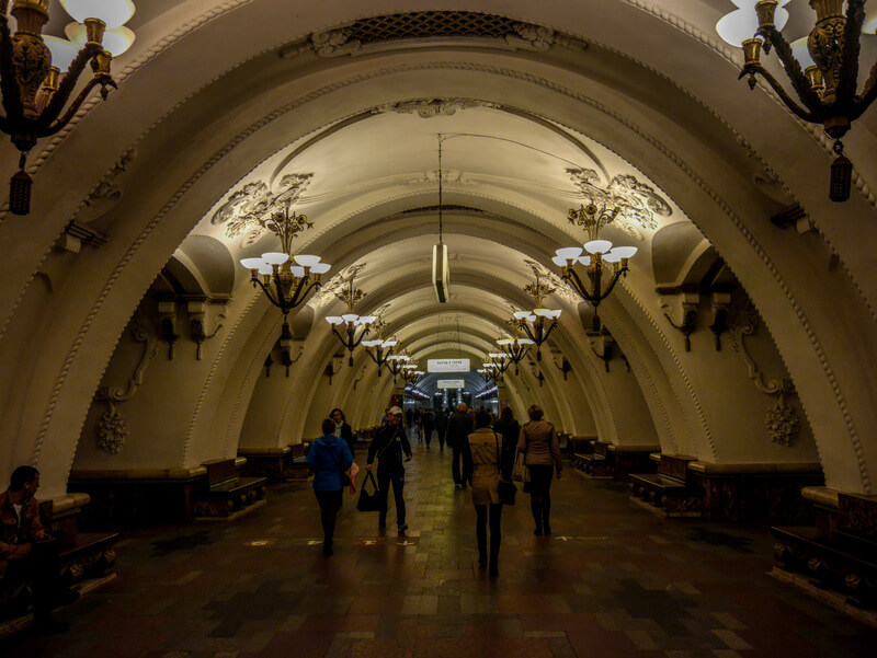 Interior of Arbatskaya metro station in Moscow, showcasing elegant chandeliers and ornate Soviet-era design