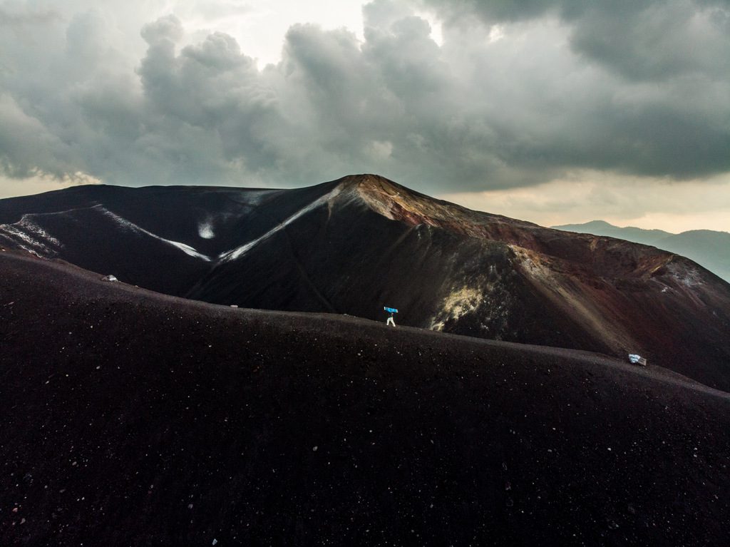 Climbing up Cerro Negro with a sandboard in hand - Volcanoes in Nicaragua