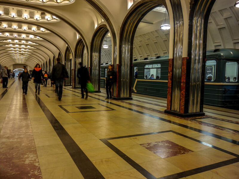 Mayakovskaya metro station in Moscow, featuring futuristic art deco design with stainless steel arches and colorful mosaics