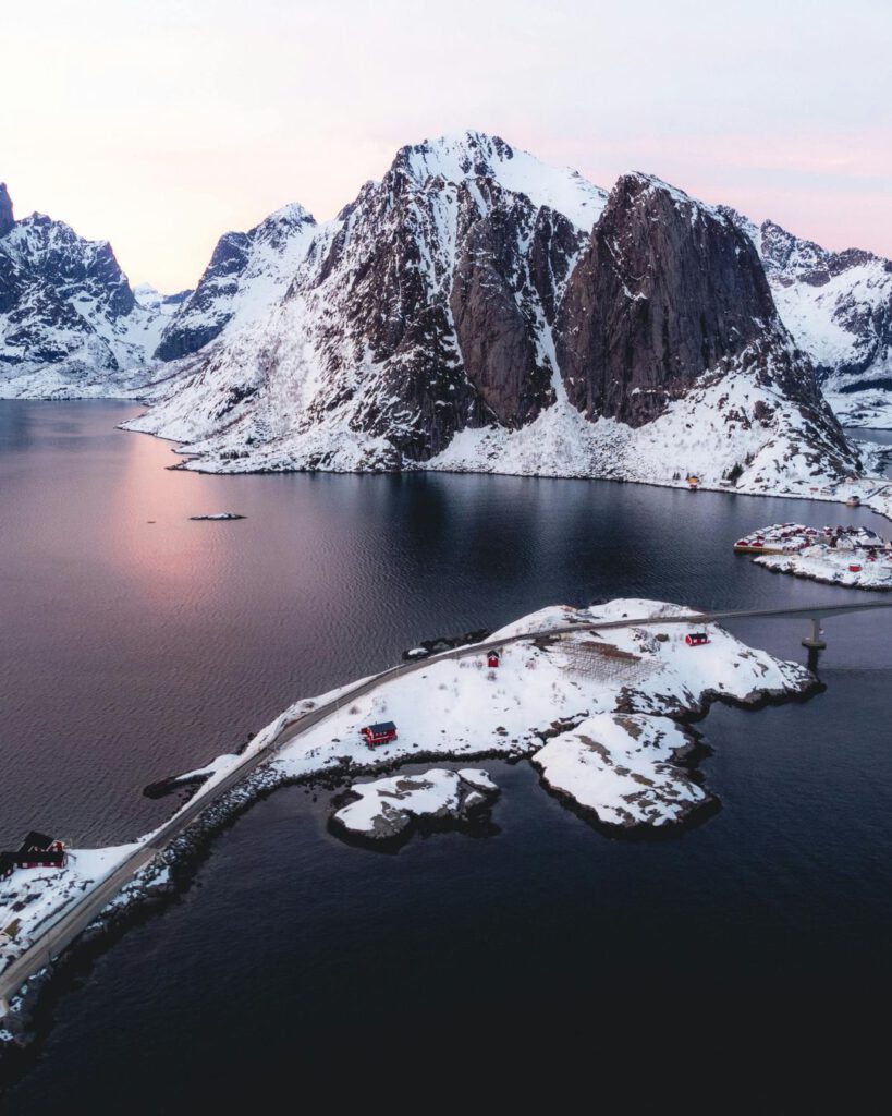 The Lofoten Islands are breathtaking in December, with jagged peaks, frozen fjords, and red fishing huts glowing against the snow.